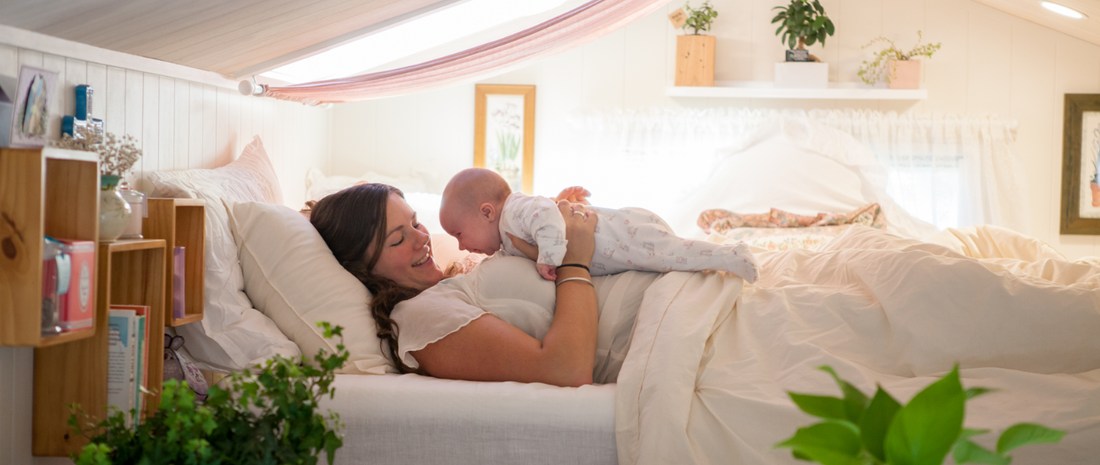 Mother and baby resting on a bed with soft bedding